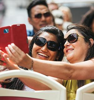 dvě ženy fotící se mobilním telefonem