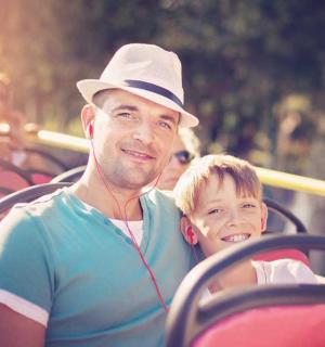 muž v klobouku a sluchátkách s malým chlapcem