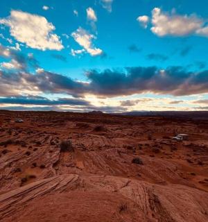 a view of a desert with vehicles in the distance