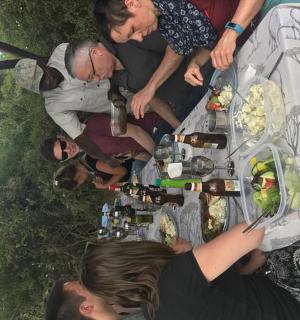 a group of people standing around a table with food