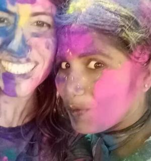 一名女子站在一名脸上涂满油彩的男子旁边