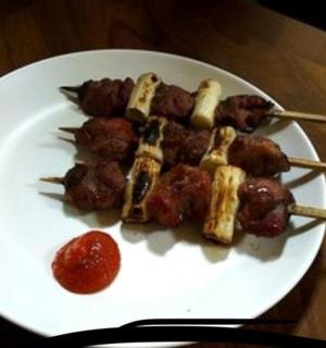 一盘有肉串和酱汁的食物