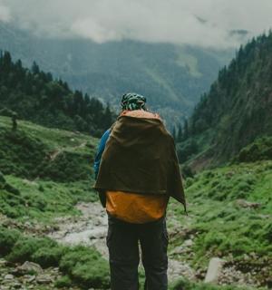 a man standing on a mountain looking at a valley