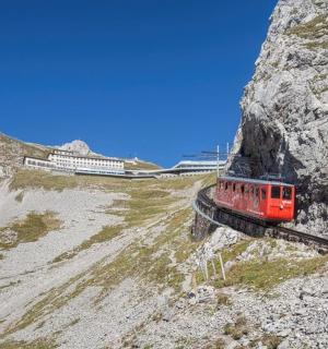 a red train on a track on a mountain