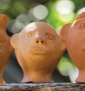 a group of clay pots with faces on them