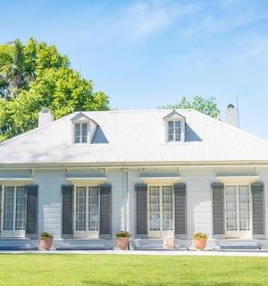 bílý dům s černými okny a dvorkem