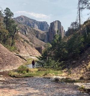 osoba kráčející po prašné cestě v kaňonu