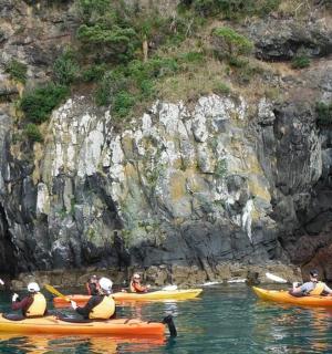一群人在洞穴附近的水中划皮划艇