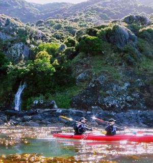 两人在河上的红色皮划艇上