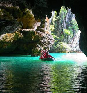 a person in a boat in a cave in the water