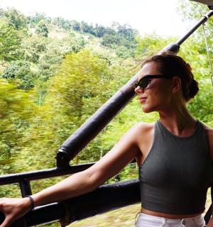 a woman in sunglasses is standing on a bridge
