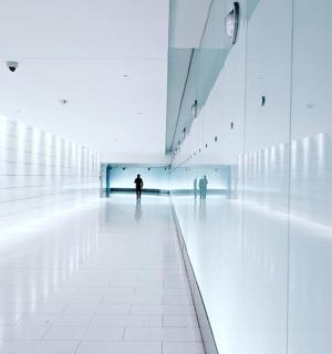 two people standing in a hallway of a building