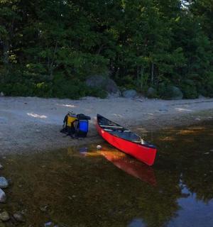 一艘红色的小船停泊在水岸边