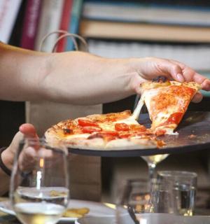 一个人拿着盘子里的一片披萨