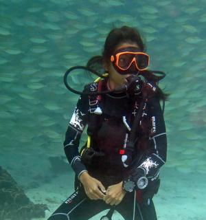 una donna che indossa una muta da sub e occhiali da sub in acqua