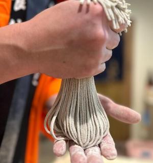 a person is holding a ball of gray yarn