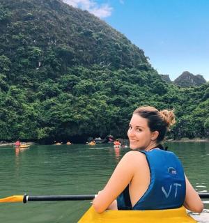 一位女士在山间河流上划皮划艇