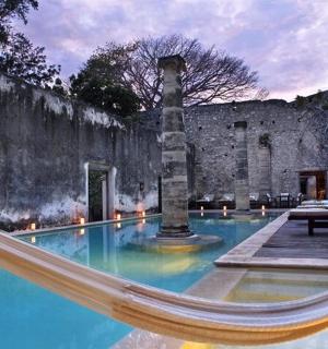 a swimming pool with a hammock in front of a building