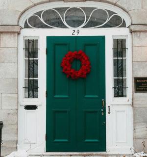 a green door of a building with a wreath on it