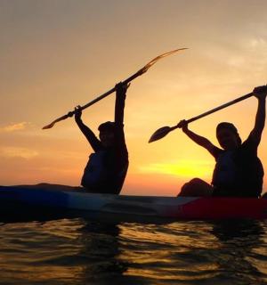 日落时分，两人在水上划皮划艇