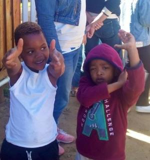 two young boys giving the thumbs up sign