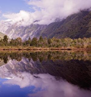a reflection of a mountain in a body of water