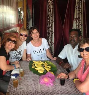 a group of people sitting at a table with bananas