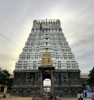 a large temple tower with people standing around it
