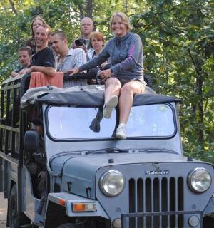 一群人坐在吉普车的车顶上