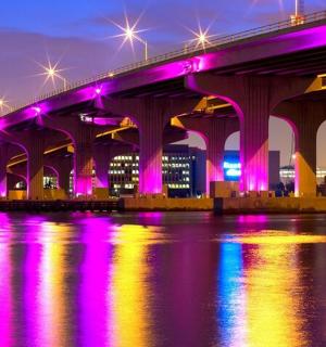 most s fialovými světly nad vodou v noci