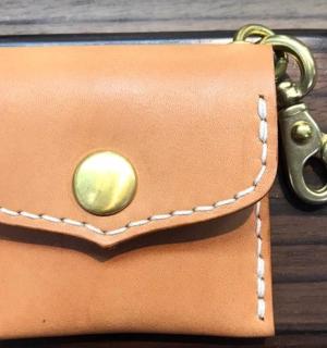 a brown purse with a key on a table