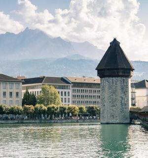 most přes řeku s budovami a horou