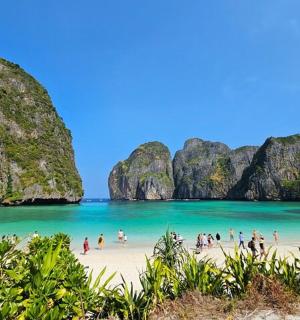 a group of people on a beach with limestone cliffs