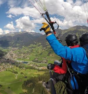 two people flying in the air with a parachute