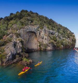 两个人在船旁的水中划皮划艇