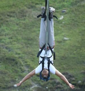 ein Mädchen hängt an einer Seilrutsche