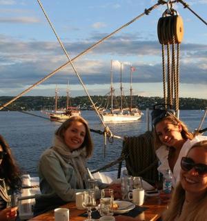 一群妇女坐在船上的一张桌子旁