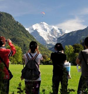 skupina lidí stojících na poli a pouštících draka