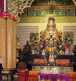 一位妇女站在寺庙的雕像前