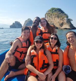 a group of people in life jackets on a boat in the water