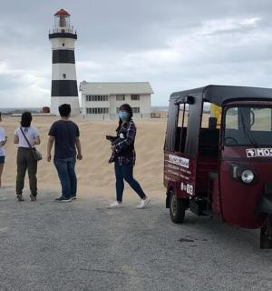 a group of people standing in front of a lighthouse