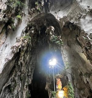 一个女人站在山洞里,山洞里有灯光