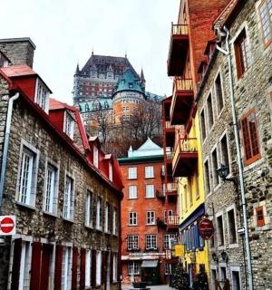 a city street with buildings and a castle in the background