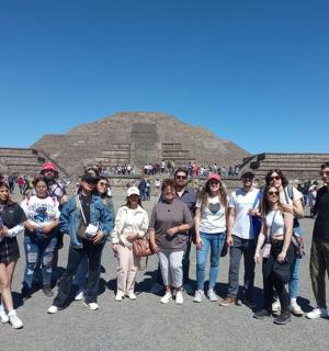 un grup de persones dretes davant d'una piràmide