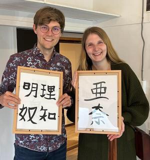 a man and a woman holding up two framed signs