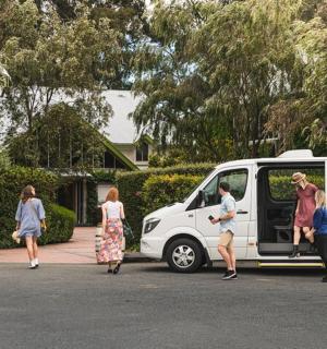 a group of people standing outside of a white van