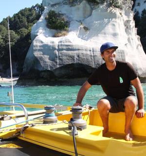 一名男子坐在水中的一艘黄色船上