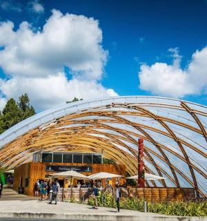 velká zakřivená budova s lidmi stojícími před ní