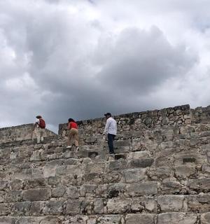a group of people standing on top of a stone wall