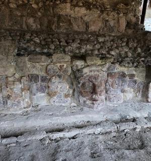 a stone wall with a bunch of art on it